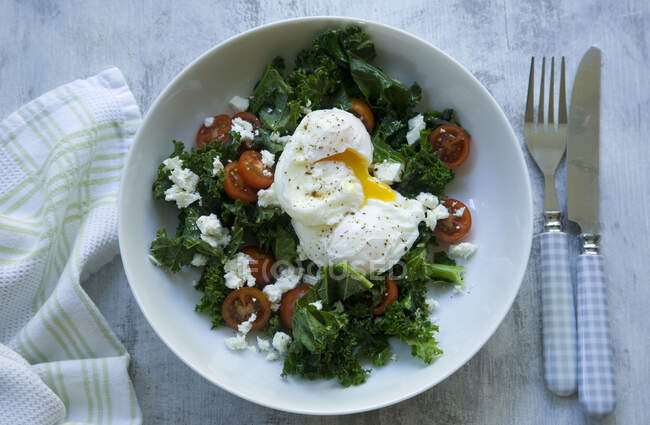 Kale salad with tomato, feta and poached eggs — Stock Photo