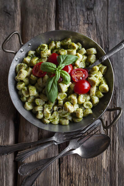Pasta with pesto sauce and basil on wooden table — Stock Photo
