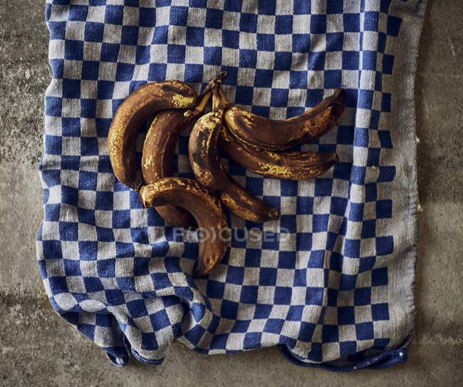 Bananas marrons em uma toalha de cozinha — Fotografia de Stock