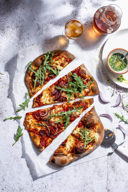 Pizza con salami, aceite de albahaca y ensalada de rúcula fresca - foto de stock