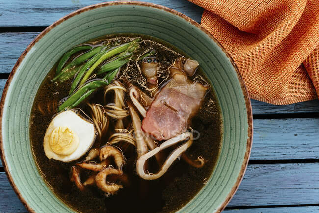 Asian noodle soup with egg and seafood — Stock Photo