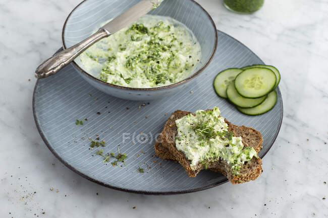 Wild garlic sheep's cheese cream on wholemeal bread with cucumber slices — Stock Photo