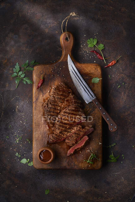 Steak grillé sur une plaque en céramique et bois sur table en marbre — Photo de stock
