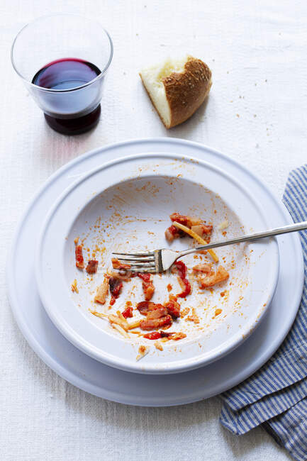 The remains of spaghetti all'amatriciana on a plate — Photo de stock