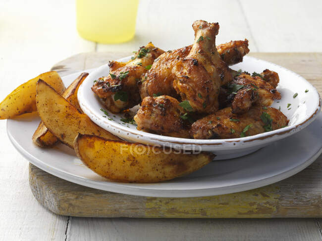 Spicy chicken wings and potato wedges — Stock Photo