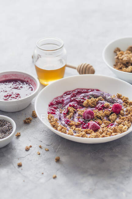 Granola with berry yoghurt, honey, chia seeds, raspberry sauce and fresh raspberries — Stock Photo