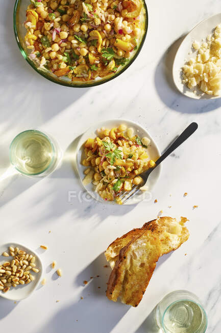 Ensalada de garbanzos con parmesano, cebolla roja, piñones y calabacines amarillos - foto de stock