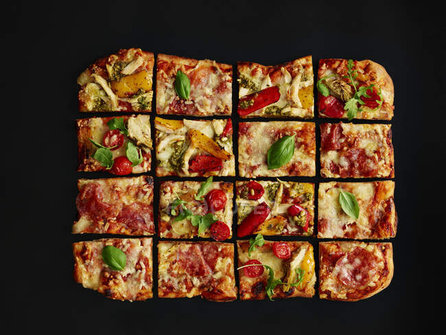 Разноцветная пицца с салями, запечённая в подносе, нарезанная — стоковое фото