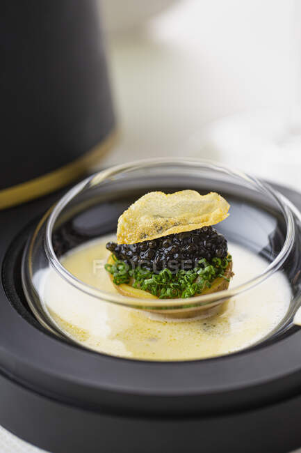 Caviar sur une pomme de terre avec de la ciboulette et une croustille — Photo de stock