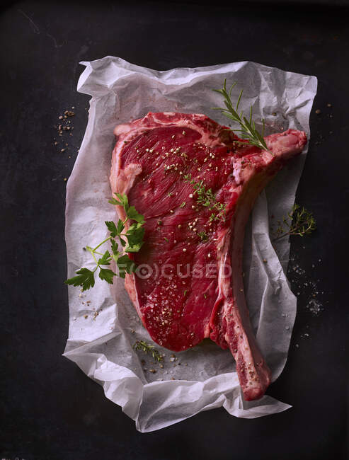 Steak cru aux épices sur papier — Photo de stock