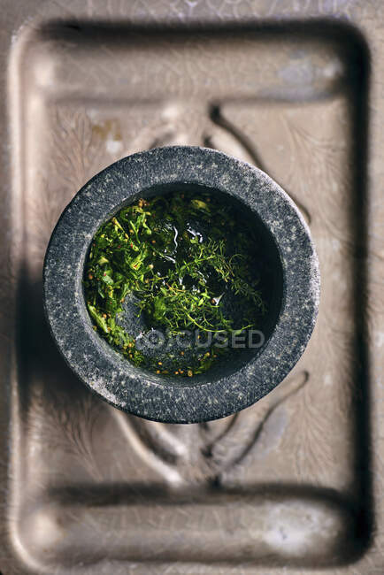 Fresh herbs and spices for chimichurri in a mortar — Stock Photo