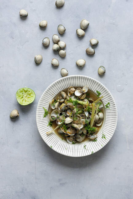 Cockles with lemongrass and lime in broth — Stock Photo