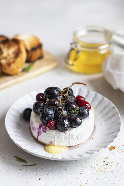 Baked camembert with red grapes and cranberries — Stock Photo