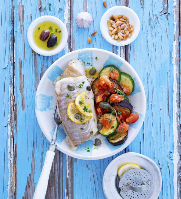 Pollack fillet with Mediterranean vegetables and pine nuts — Stock Photo