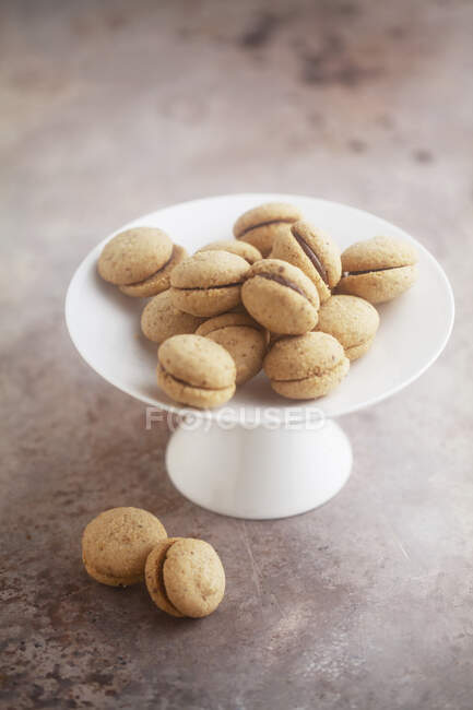 Baci di dama, biscuits aux noisettes italiennes sur un stand de gâteau — Photo de stock