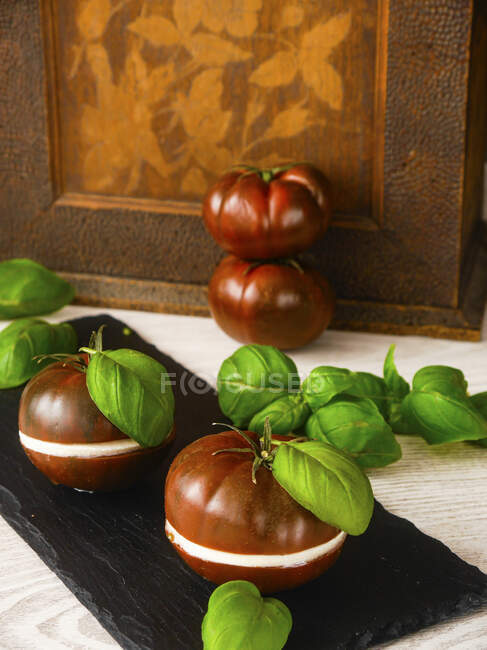 Black tomatoes filled with a slice of mozzarella — Stock Photo