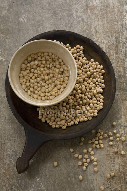 Chickpeas dry and soaking in water — Stock Photo