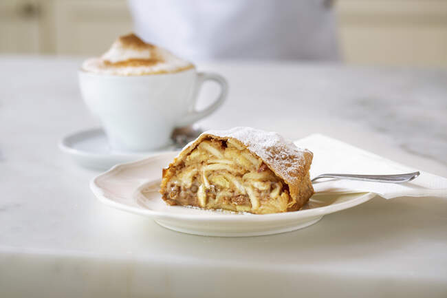 A slice of apple strudel and a cup of coffee — Stock Photo