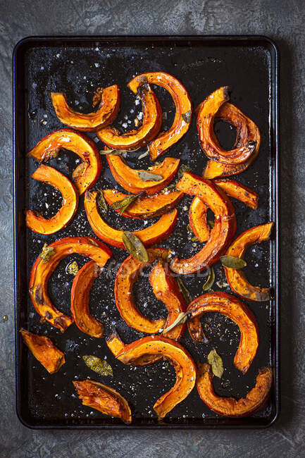 Roasted pumkin wedges with salt pepper and sage — Stock Photo