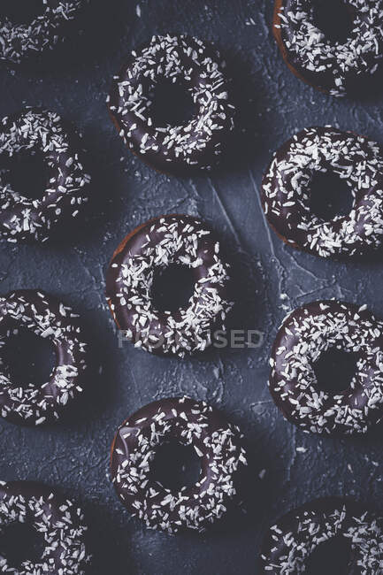 Donuts avec glaçage au chocolat et lambeaux de noix de coco — Photo de stock