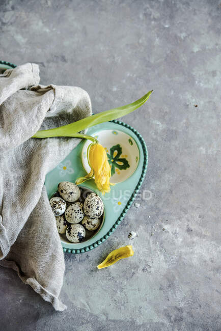 Uova di quaglia in contenitore con fiore e stoffa — Foto stock