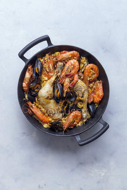 Paella con pollo, cozze e gamberi in padella — Foto stock
