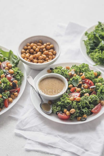 Salad with roasted chickpeas, tomatoes, kale and mustard vinaigrette sauce — Stock Photo