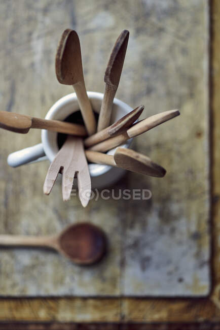 Cucharas y utensilios de madera en jarra de porcelana - foto de stock