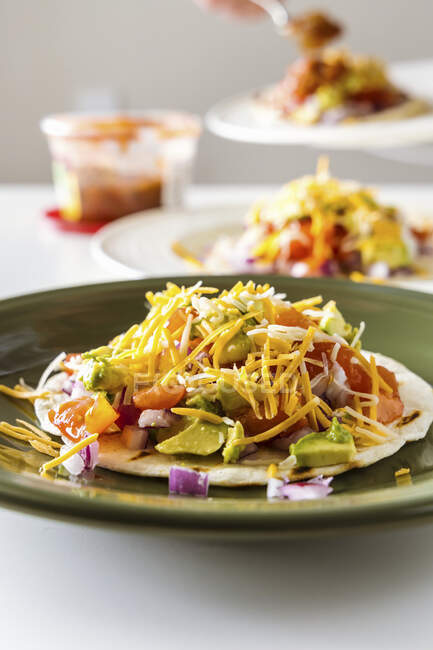 Fisch-Tacos mit gegrilltem Wolfsbarsch, Avocado, Tomaten, roten Zwiebeln und Käse — Stockfoto