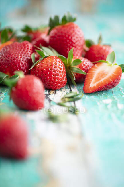 Several strawberries on a turquoise wooden background — Stock Photo