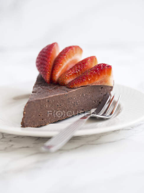 Slice of flourless chocolate fudge cake with strawberries — Stock Photo