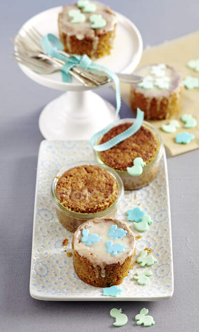 Mini carrot cakes baked in jars decorated with icing and sugar decorations — Stock Photo