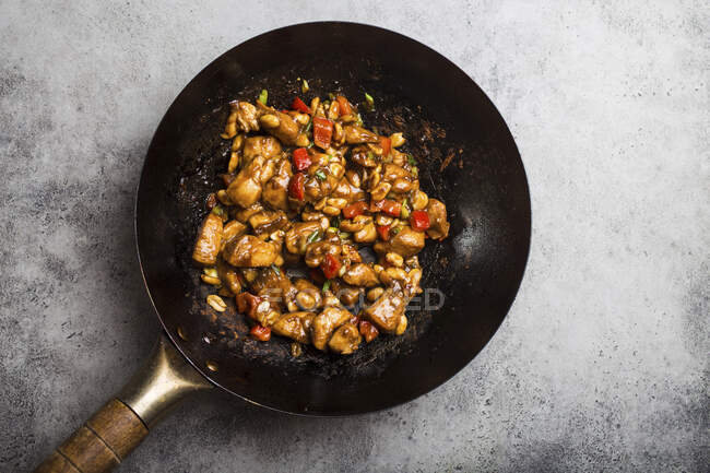 Top view of Kung Pao chicken, stir-fried Chinese traditional dish with chicken, peanuts, vegetables, chili peppers in a wok pan — Stock Photo