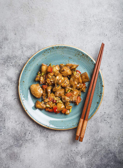 Draufsicht auf das Kung-Pao-Huhn auf einem Teller, fertig zum Essen. Gebratenes traditionelles chinesisches Gericht — Stockfoto