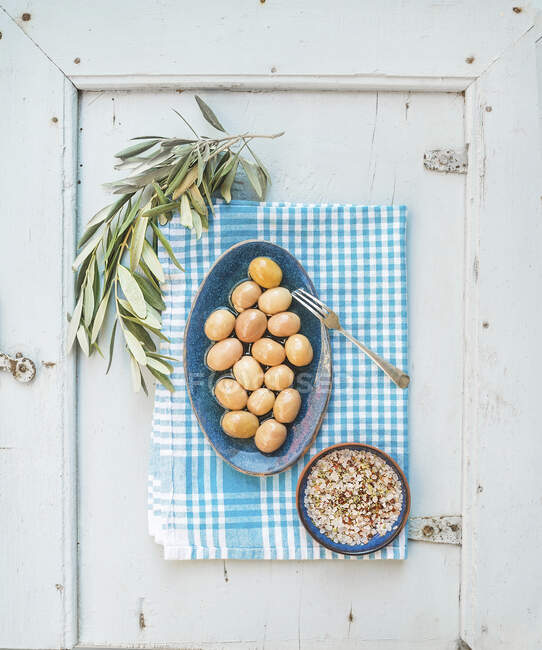 Зелені великі оливки в синій керамічній тарілці зі спеціями — стокове фото