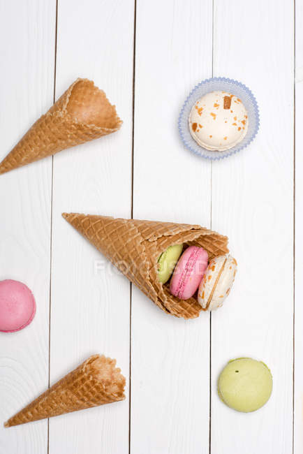 Waffelkegel mit bunten Macarons — Stockfoto