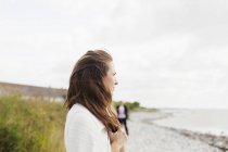Mujer de pie en la playa contra el cielo - foto de stock