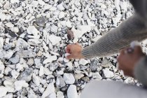 Hombre recogiendo piedras en la playa - foto de stock