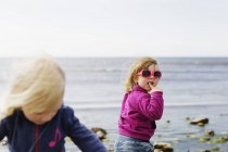 Mädchen stehen am Strand — Stockfoto