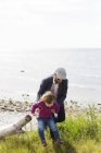 Батько тримає дочку на пляжі — стокове фото