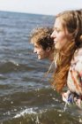 Amigos em pé junto ao mar — Fotografia de Stock