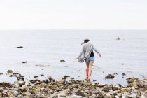 Женщина гуляет по пляжу — стоковое фото