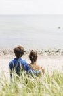 Couple assis à la plage — Photo de stock