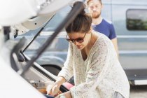 Woman picking clothes from car — Stock Photo
