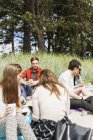 Amigos disfrutando de picnic en el bosque - foto de stock