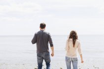 Homme et femme debout sur le rivage — Photo de stock