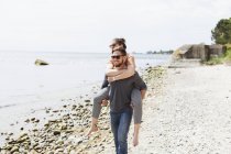 Mann trägt Freund auf dem Rücken — Stockfoto
