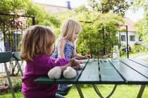 Sisters playing on table — Stock Photo