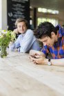 Man looking at friend using smart phone — Stock Photo