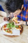 Чоловік їсть піцу в ресторані — стокове фото